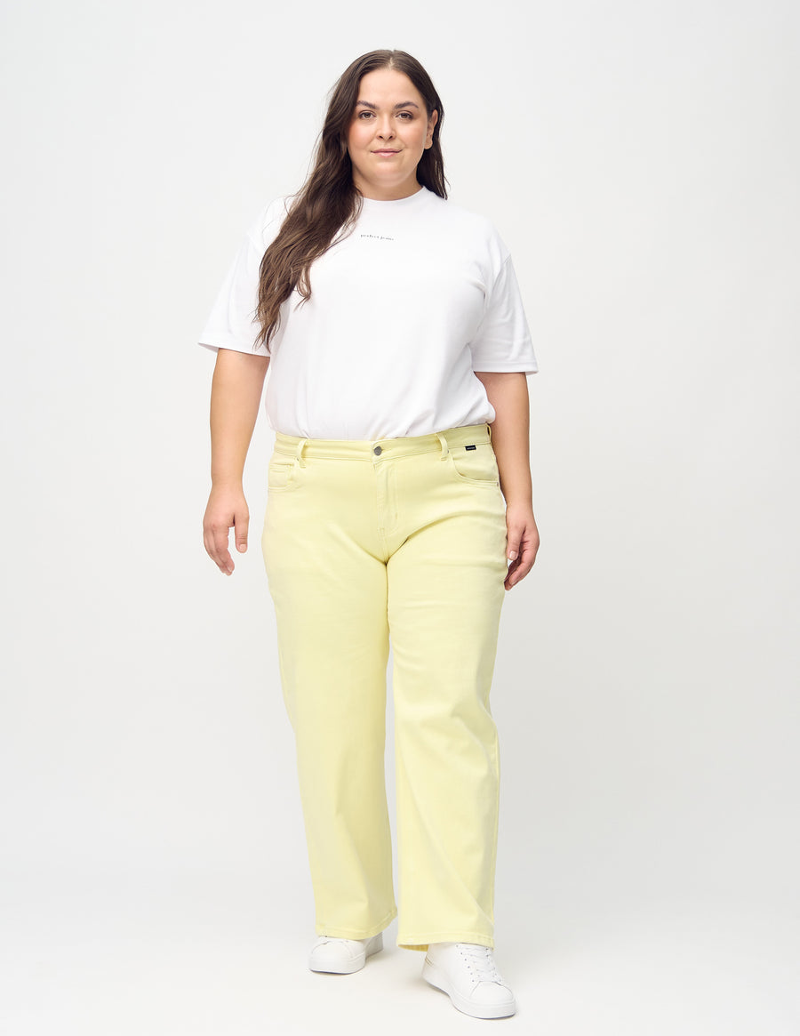 Loose-jeans til kvinner i lysegul, fargen Lemonades. Helhetsbilde av en plus size-modell med løstsittende jeans.
