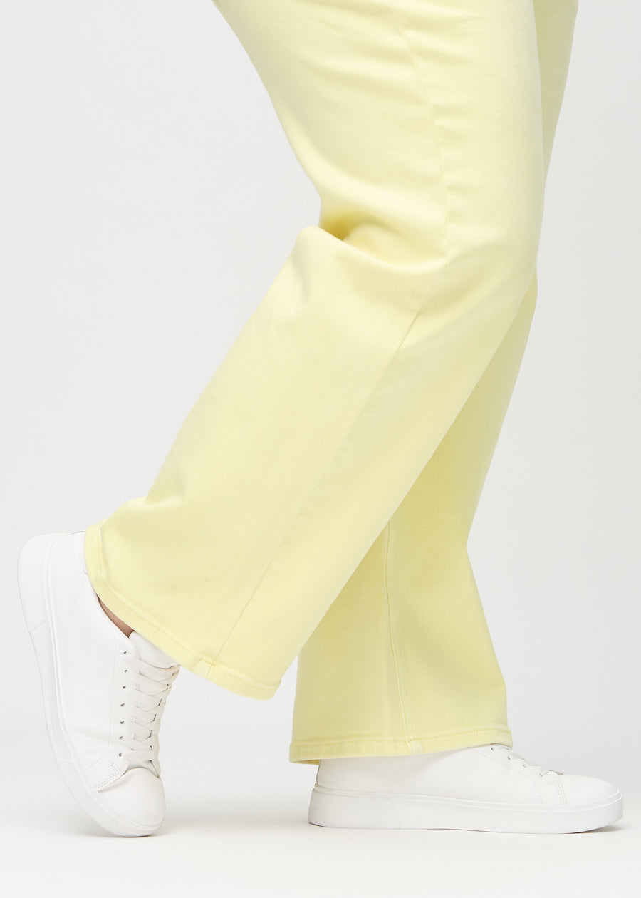 Loose-jeans til kvinner i lysegul, fargen Lemonades. Nærbilde ved anklene på en plus size-modell, som viser de vide benavslutningene.