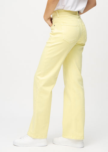 Loose-jeans til kvinner i lysegul, fargen Lemonades. Sett fra siden på en modell, med synlig løs passform.