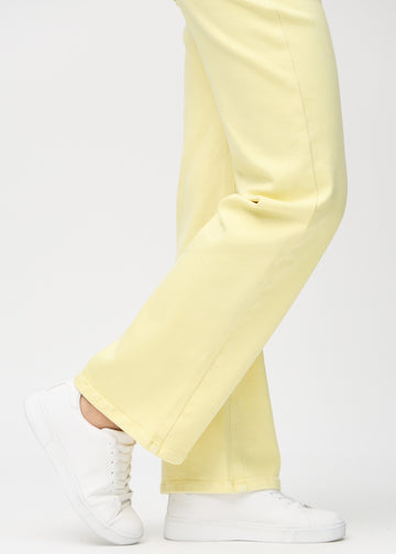 Loose-jeans til kvinner i lysegul, fargen Lemonades. Nærbilde ved anklene på en modell, som viser de vide benavslutningene.