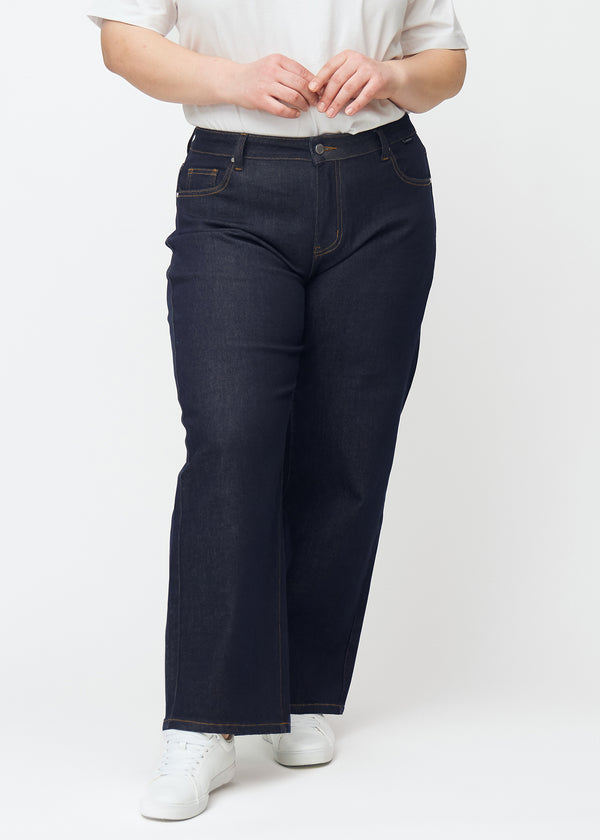 Dyp mørkeblå denim jeans til kvinner i fargen Midnights med loose passform sett forfra på plus-size-modell.