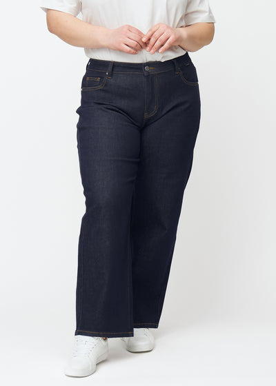 Dyp mørkeblå denim jeans til kvinner i fargen Midnights med loose passform sett forfra på plus-size-modell.