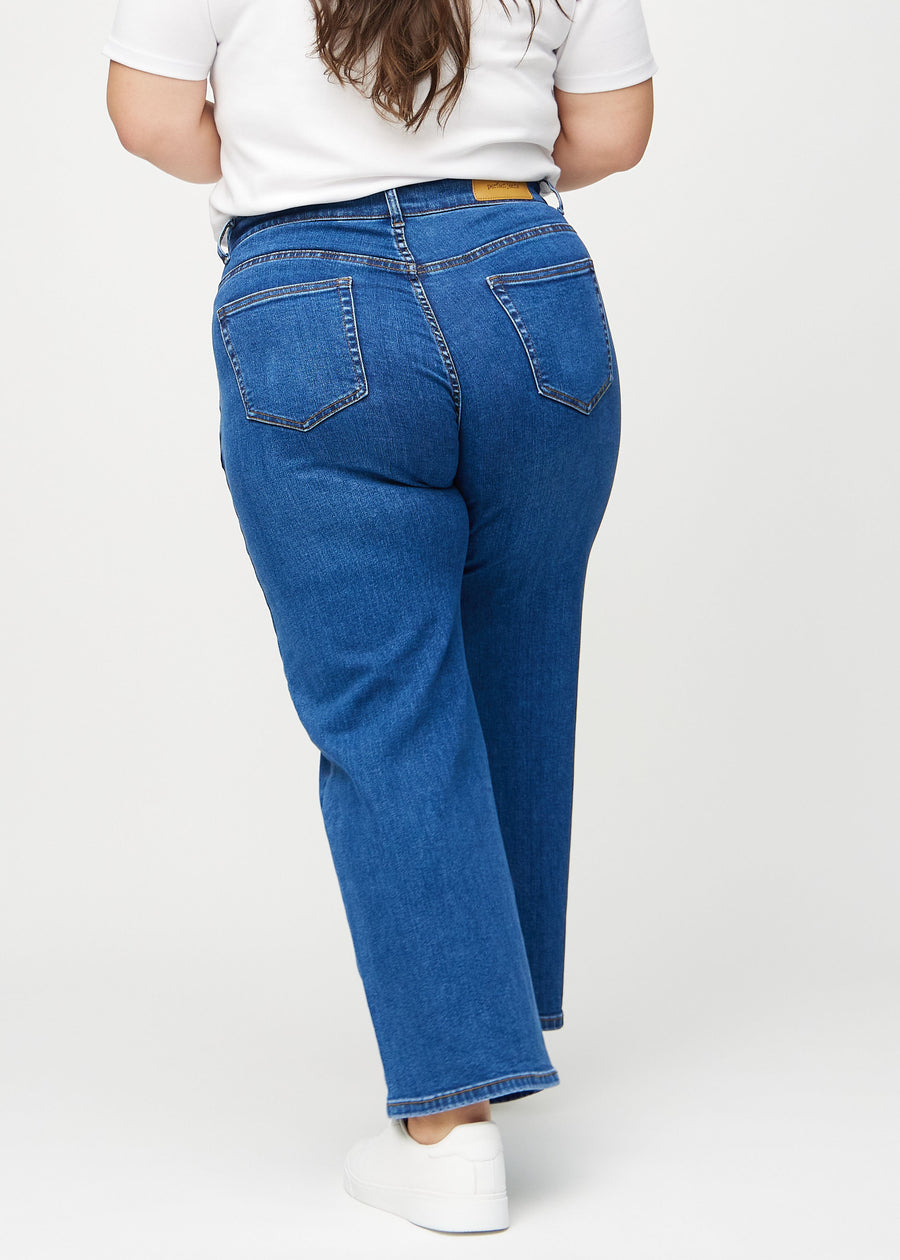 Loose-jeans til kvinner i mørkeblå, fargen Oceans. Sett bakfra på en plus size-modell, slik at hele den løse passformen vises.