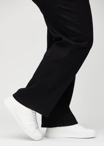 Anklene på en plus-size-modell, så man kan se hvor løst jeansene sitter i en Loose passform.