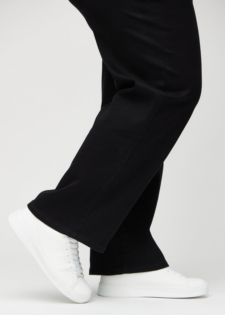 Anklene på en plus-size-modell, så man kan se hvor løst jeansene sitter i en Loose passform.