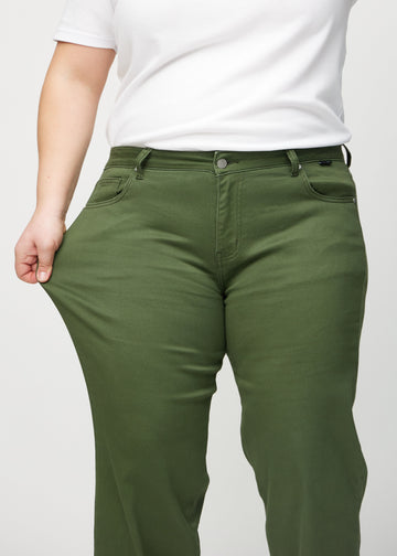 Loose-jeans til kvinner i mørkegrønn, fargen Renewals. En plus size-modell strekker jeansstoffet ved låret for å vise stretchen.