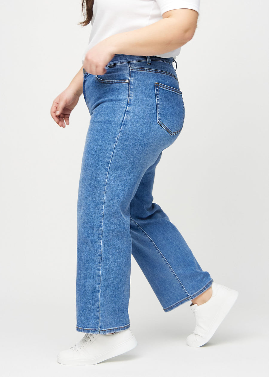 Loose-jeans til kvinner i blå, fargen Rivers. Sett fra siden på en plus size-modell, med synlig løs passform.