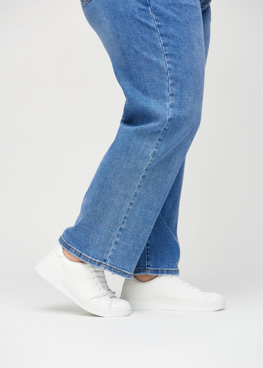 Loose-jeans til kvinner i blå, fargen Rivers. Nærbilde ved anklene på en plus size-modell, som viser de vide benavslutningene.