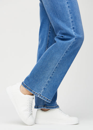 Loose-jeans til kvinner i blå, fargen Rivers. Nærbilde ved anklene på en modell, som viser de vide benavslutningene.