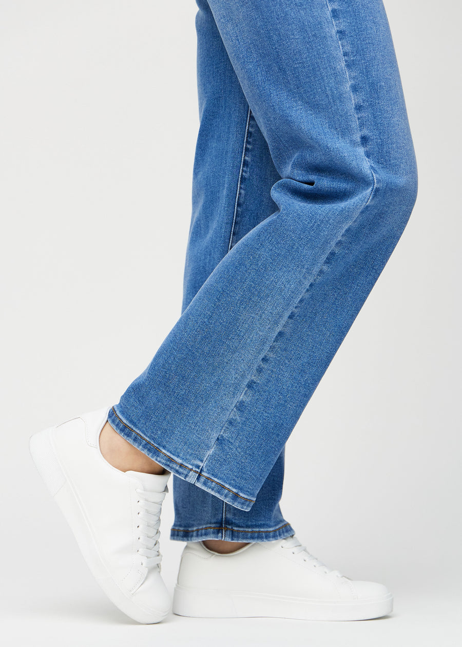 Loose-jeans til kvinner i blå, fargen Rivers. Nærbilde ved anklene på en modell, som viser de vide benavslutningene.