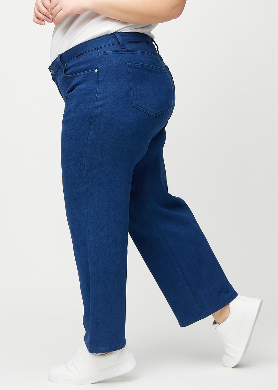 Loose-jeans til kvinner i mørkeblå, fargen Royals. Sett fra siden på en plus size-modell, med synlig løs passform.