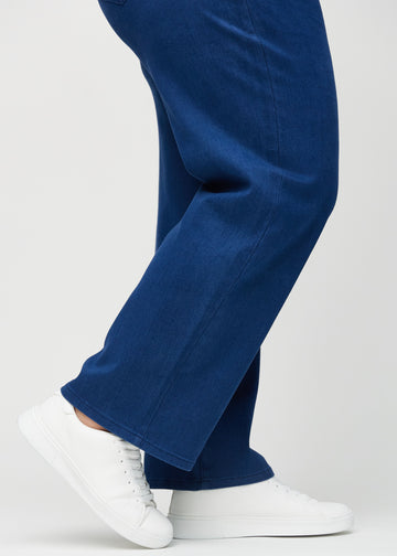 Loose-jeans til kvinner i mørkeblå, fargen Royals. Nærbilde ved anklene på en plus size-modell, som viser de vide benavslutningene.