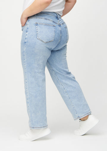 Loose-jeans til kvinner i lyseblå, fargen Waves. Sett fra siden på en plus size-modell, med synlig løs passform.