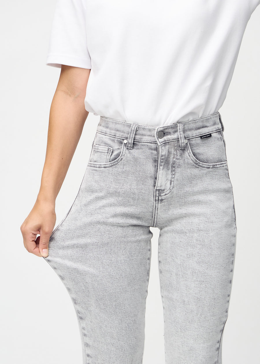 Regular-jeans til kvinner i lysegrå, fargen Ashes. En modell strekker stoffet ved låret for å vise stretchen.