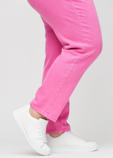Regular-jeans til kvinner i lyserosa, fargen Flamingos. Nærbilde ved anklene på en plus size-modell, som viser de rette benavslutningene.