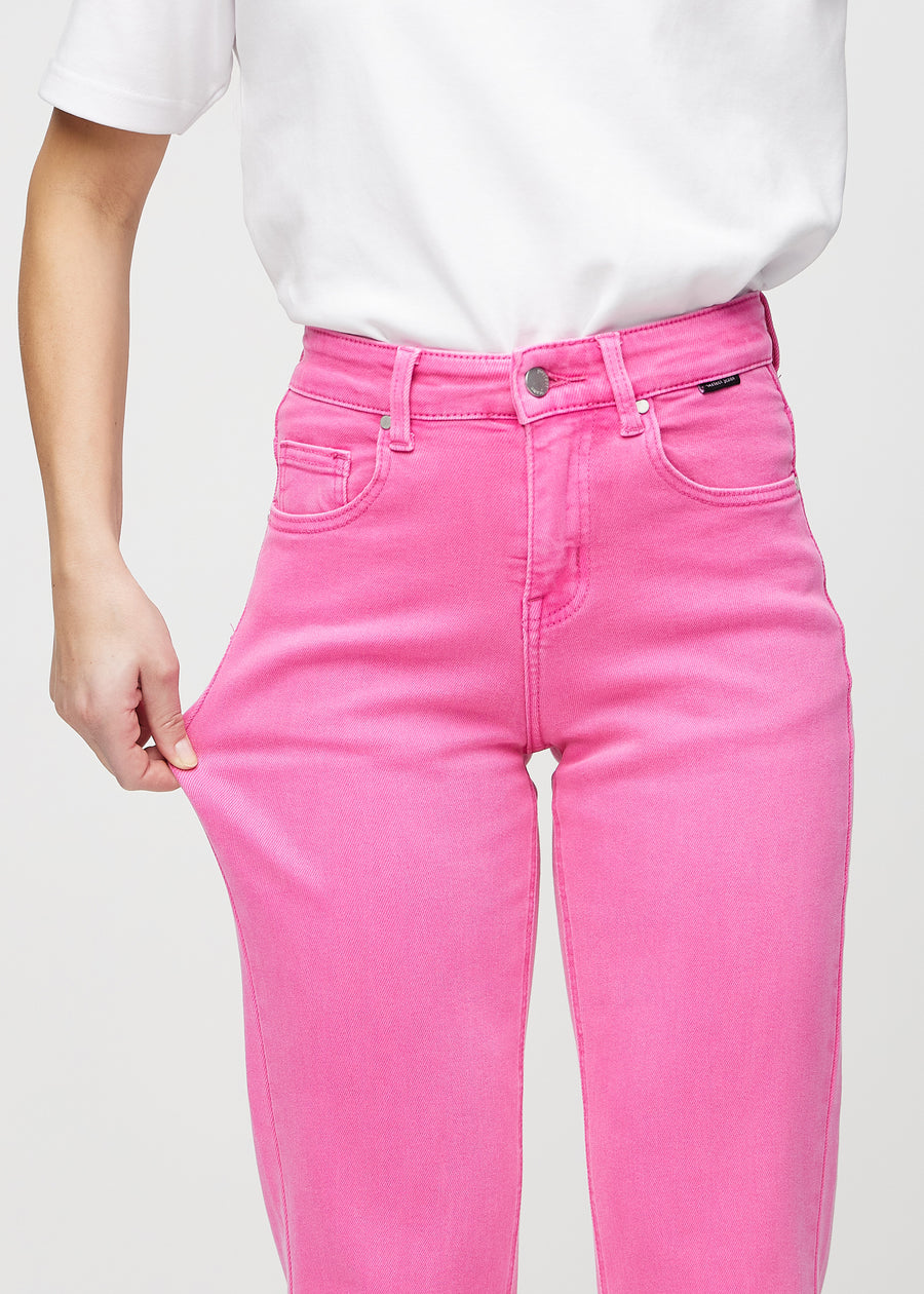 Regular-jeans til kvinner i lyserosa, fargen Flamingos. En modell strekker stoffet ved låret for å vise stretchen.