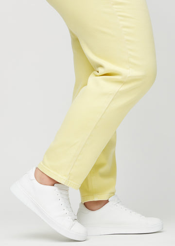 Regular-jeans til kvinner i lysegul, fargen Lemonades. Nærbilde ved anklene på en plus size-modell, som viser de rette benavslutningene.