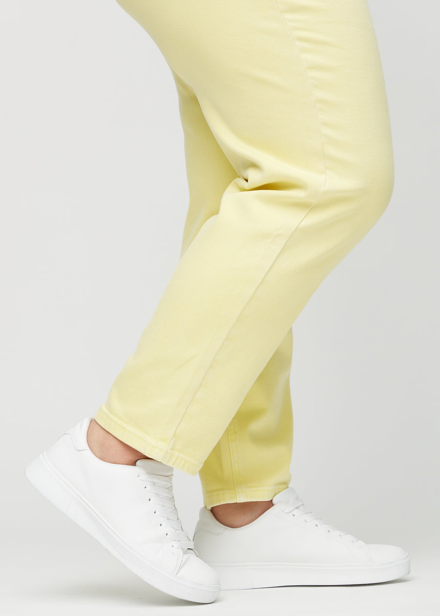 Regular-jeans til kvinner i lysegul, fargen Lemonades. Nærbilde ved anklene på en plus size-modell, som viser de rette benavslutningene.