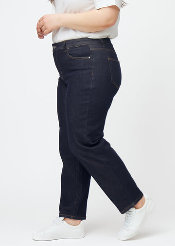 Dyp mørkeblå denim jeans til kvinner i fargen Midnights med regular passform sett fra siden på plus-size-modell.