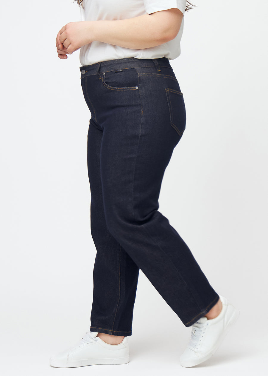Dyp mørkeblå denim jeans til kvinner i fargen Midnights med regular passform sett fra siden på plus-size-modell.