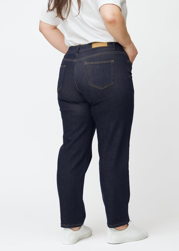 Dyp mørkeblå denim jeans til kvinner i fargen Midnights sett bakfra på plus-size-modell.