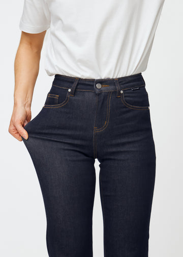 Modell strekker dyp mørkeblå denim jeans til kvinner i fargen Midnights ved låret for å vise materialets stretch.