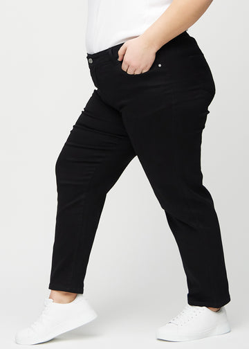 Svarte regular jeans sett fra siden på en plus-size-modell.
