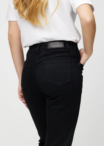 Svarte regular jeans sett bakfra på nært hold for å vise detaljer.