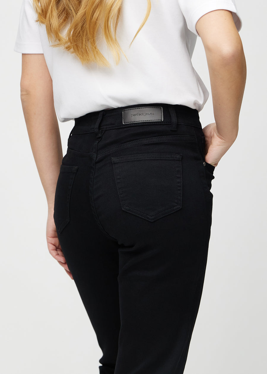 Svarte regular jeans sett bakfra på nært hold for å vise detaljer.