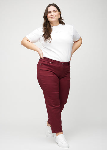 Regular-jeans til kvinner i mørkerød, fargen Santas. Helhetsbilde av en plus size-modell med jeansen på.