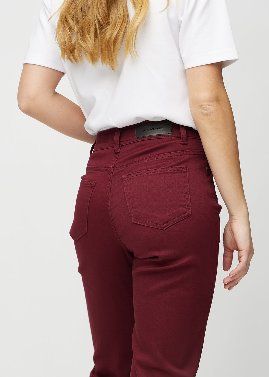 Regular-jeans til kvinner i mørkerød, fargen Santas. Nærbilde bakfra på en modell, som viser passform og detaljer.