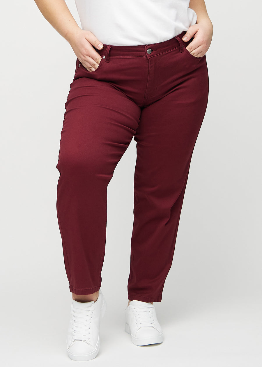 Regular-jeans til kvinner i mørkerød, fargen Santas. Sett forfra på en plus size-modell, med en klassisk rett benfasong.