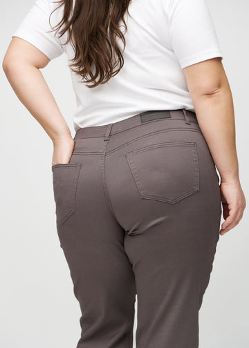 Regular-jeans til kvinner i gråbrun, fargen Thunders. Nærbilde bakfra på en plus size-modell, som viser passform og detaljer.
