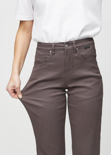 Regular-jeans til kvinner i gråbrun, fargen Thunders. En modell strekker stoffet ved låret for å vise stretchen.