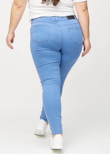 Skinny-jeans til kvinner i blå, fargen Geraniums. Sett bakfra på en plus size-modell, slik at hele passformen vises.