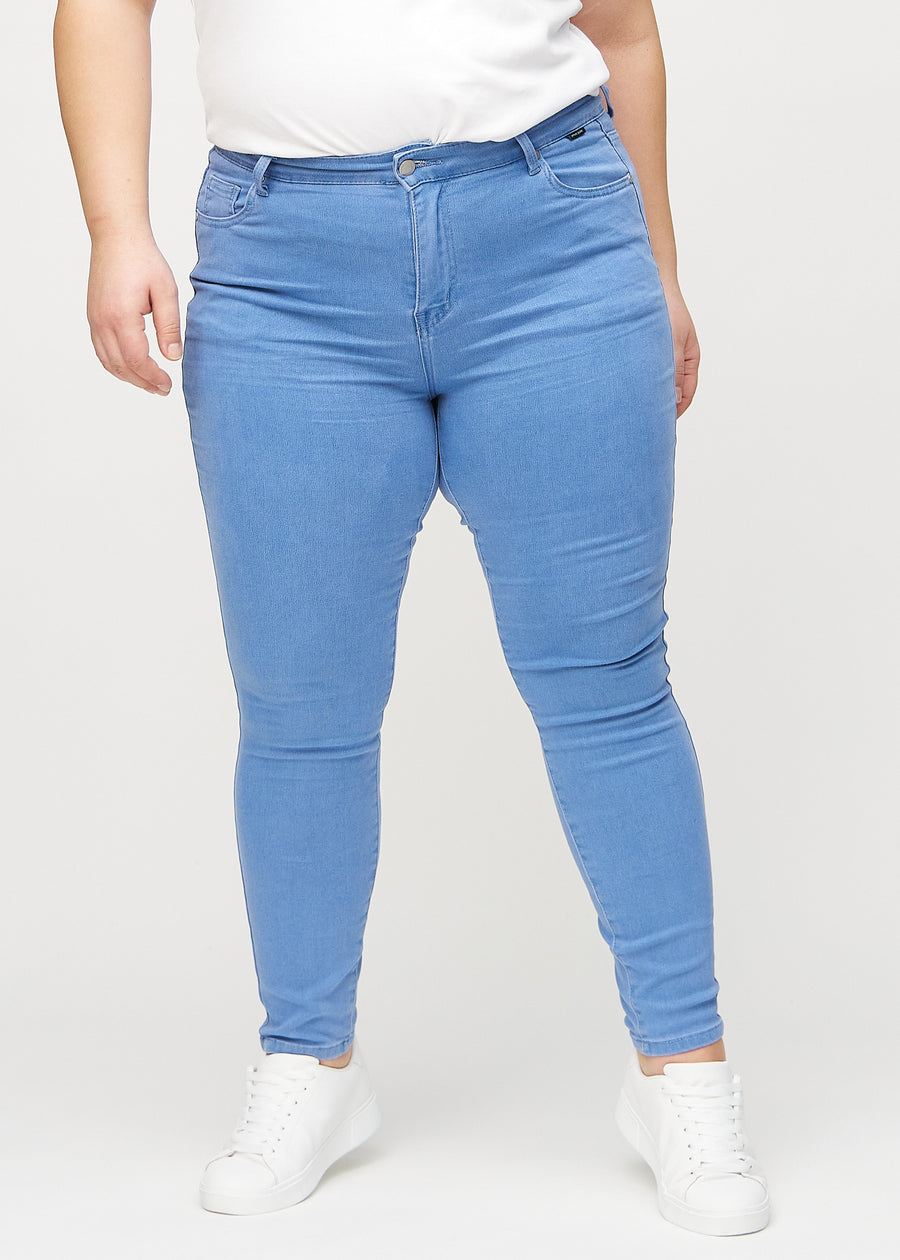 Skinny-jeans til kvinner i blå, fargen Geraniums. Sett forfra på en plus size-modell, med tett passform rundt bena.