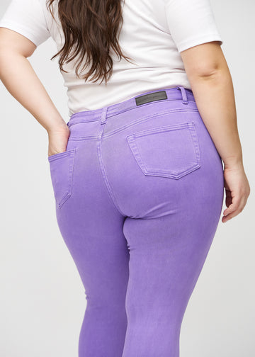 Skinny-jeans til kvinner i lilla, fargen Lavenders. Nærbilde bakfra på en plus size-modell for å vise detaljer.