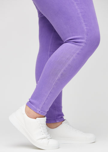 Skinny-jeans til kvinner i lilla, fargen Lavenders. Nærbilde ved anklene på en plus size-modell, som viser de tettsittende benåpningene.