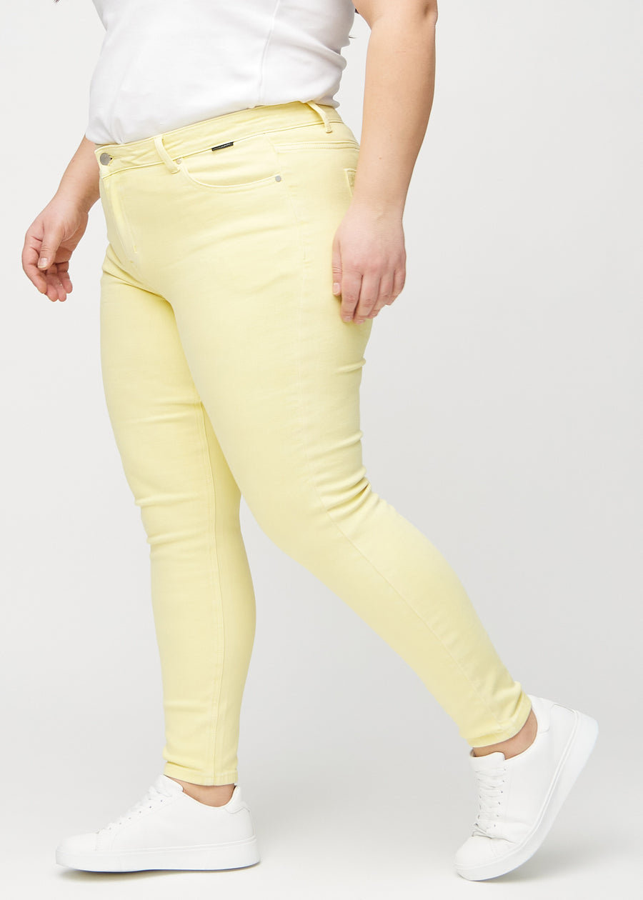 Skinny-jeans til kvinner i lysegul, fargen Lemonades. Sett fra siden på en plus size-modell.