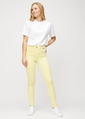 Skinny-jeans til kvinner i lysegul, fargen Lemonades. Helhetsbilde av en modell med jeansene på.