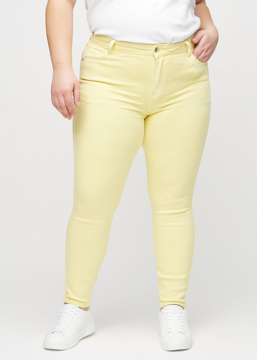 Skinny-jeans til kvinner i lysegul, fargen Lemonades. Sett forfra på en plus size-modell, med tettsittende ben.
