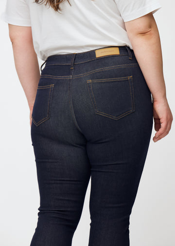 Dyp mørkeblå denim jeans til kvinner i fargen Midnights sett bakfra på nært hold på plus-size-modell.