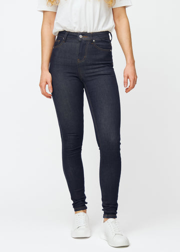 Dyp mørkeblå denim jeans til kvinner i fargen Midnights med skinny passform, som sitter tett fra midje til ankel, sett forfra.