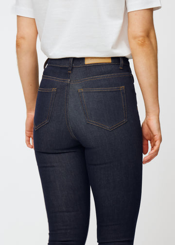 Dyp mørkeblå denim jeans til kvinner i fargen Midnights sett bakfra på nært hold for å vise passform og detaljer.
