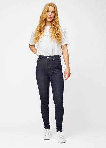 Fullt bilde av modell i dyp mørkeblå denim jeans til kvinner i fargen Midnights med skinny passform.