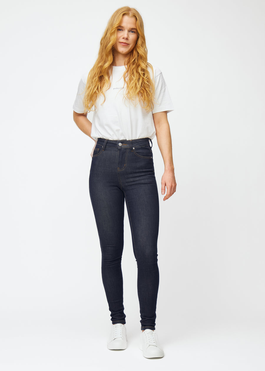 Fullt bilde av modell i dyp mørkeblå denim jeans til kvinner i fargen Midnights med skinny passform.