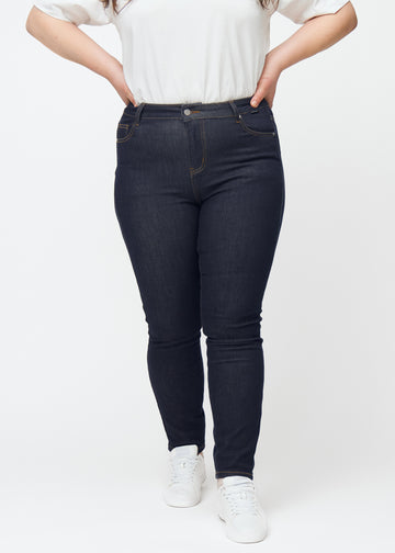 Dyp mørkeblå denim jeans til kvinner i fargen Midnights med skinny passform sett forfra på plus-size-modell.