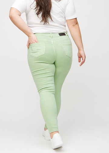 Skinny-jeans til kvinner i lysegrønn, fargen Mints. Sett bakfra på en plus size-modell, slik at hele passformen vises.