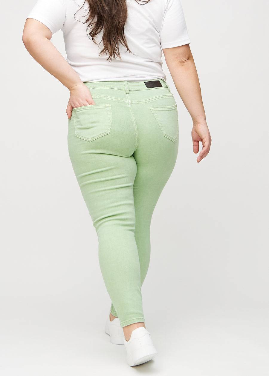 Skinny-jeans til kvinner i lysegrønn, fargen Mints. Sett bakfra på en plus size-modell, slik at hele passformen vises.