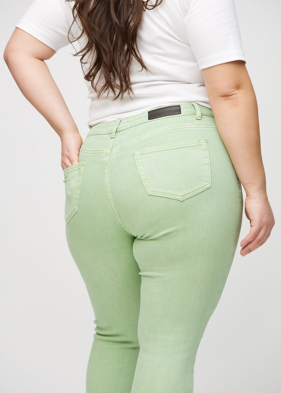 Skinny-jeans til kvinner i lysegrønn, fargen Mints. Nærbilde bakfra på en plus size-modell for å vise detaljer.